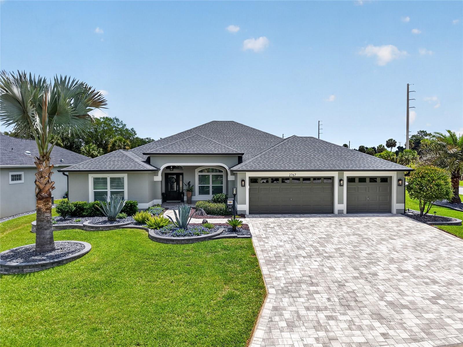Central Florida home with palm tree and paver driveway